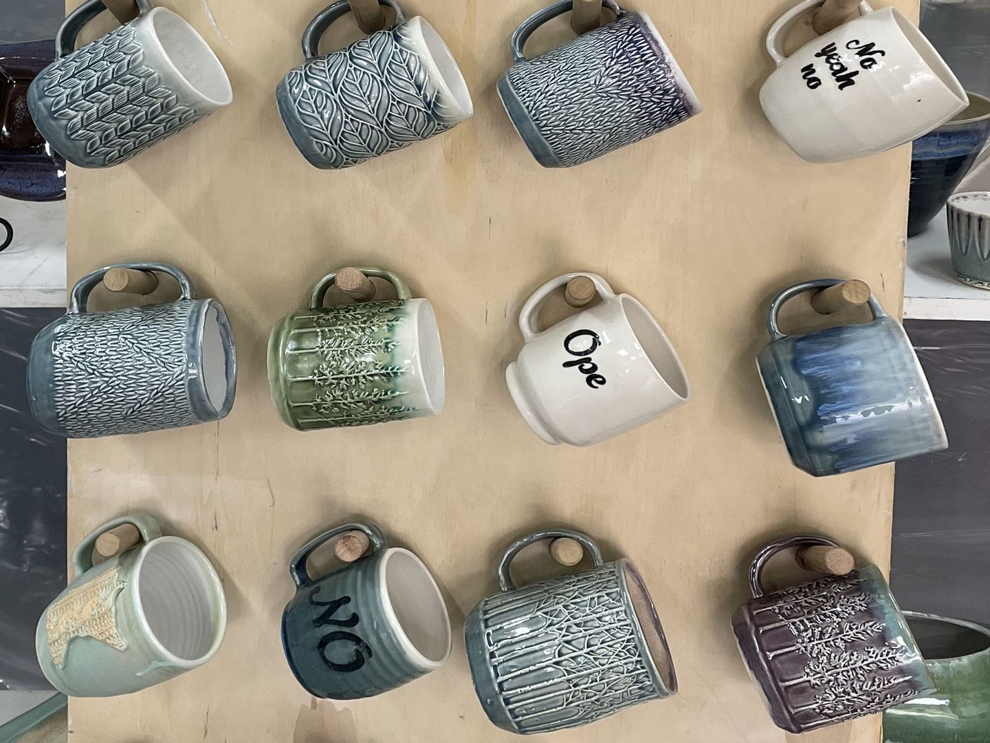 A wall display of handmade ceramic mugs from Sheepish Potter.
